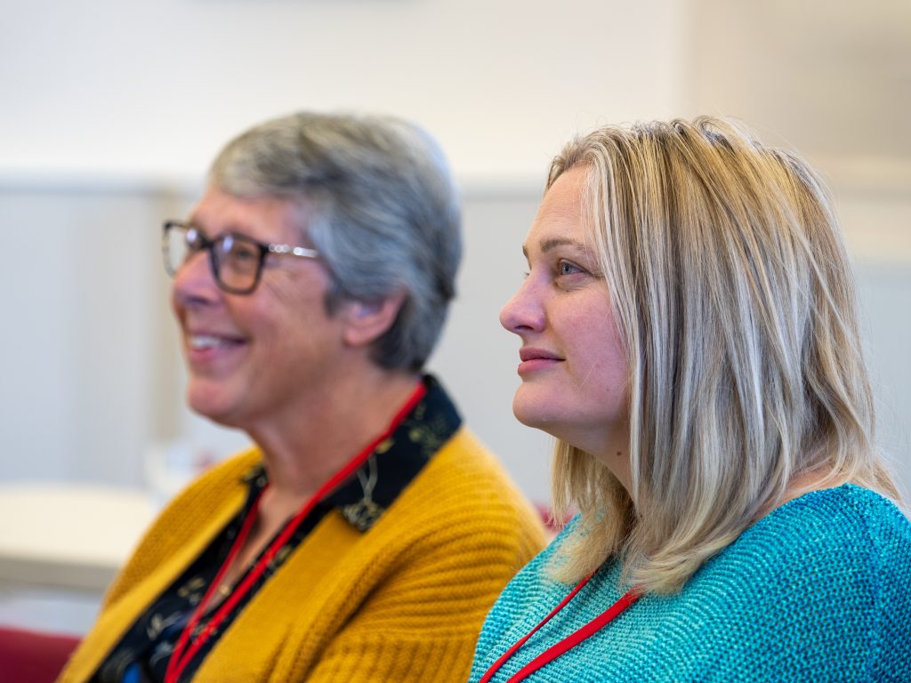 Two women listening carefully in a classroom