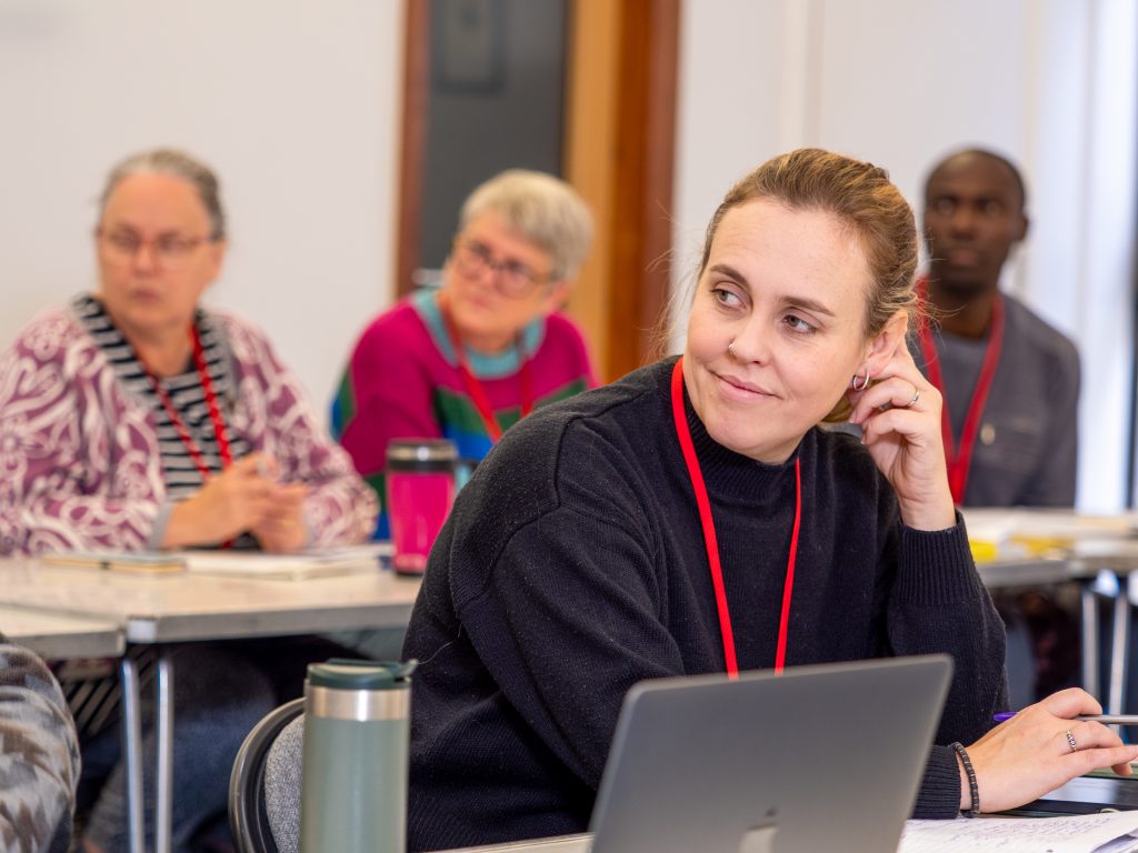 A woman sitting in a classroom talking to classmates