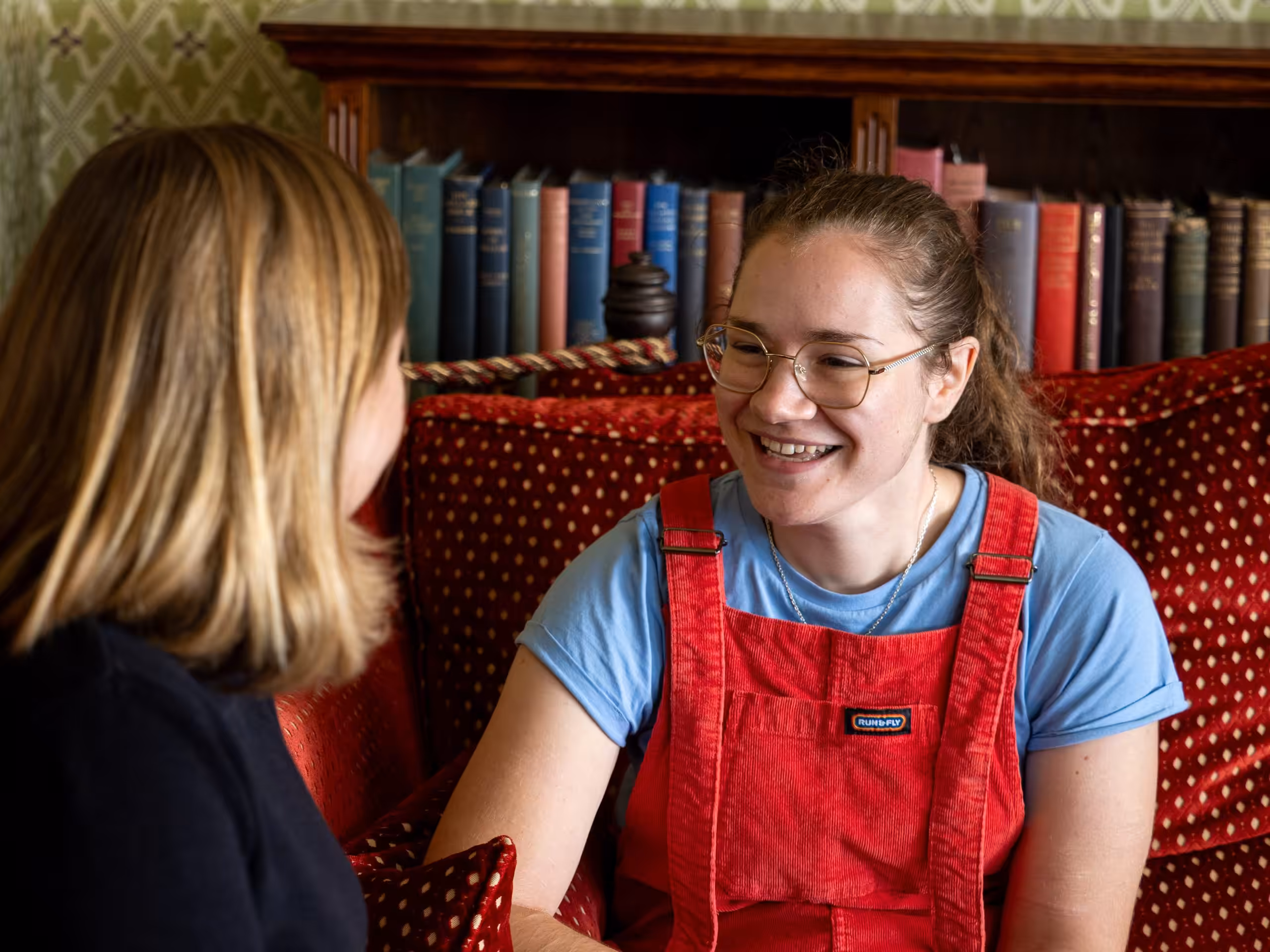 A woman talking to another woman who is smiling and looking encouraged